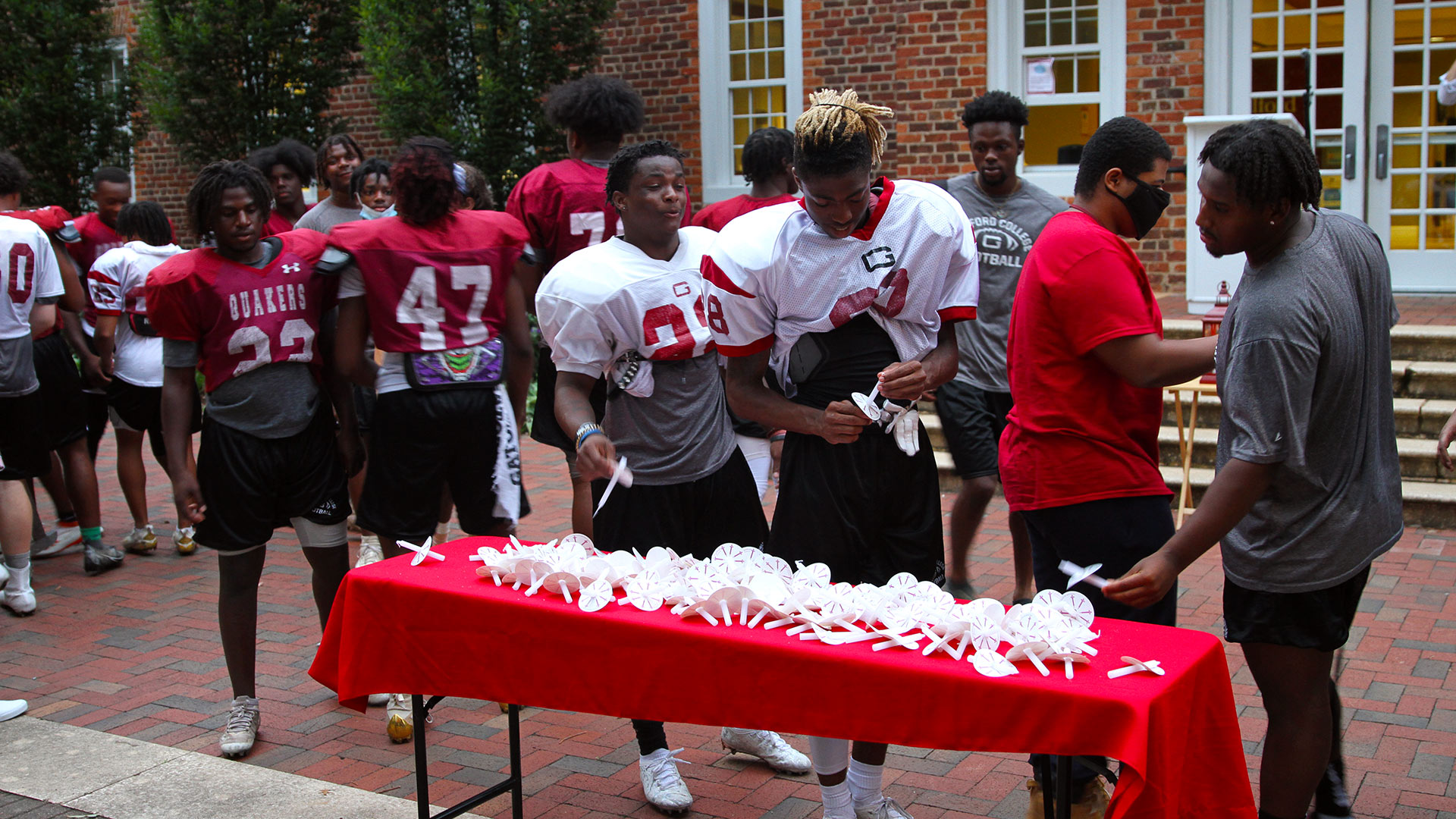 A crowd of football players arrives to select their candles.
