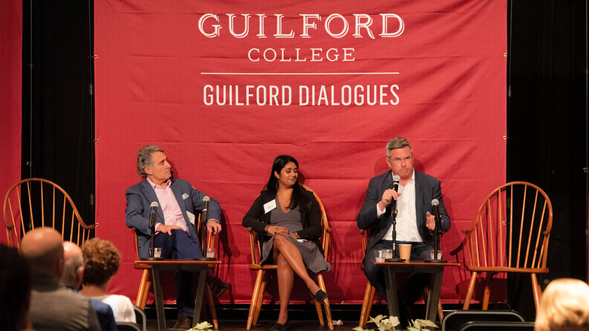 On stage at the Guilford Dialogues, seated in chairs, from left: Byron Loflin, Roberta Lobo, and Graham Macmillan.