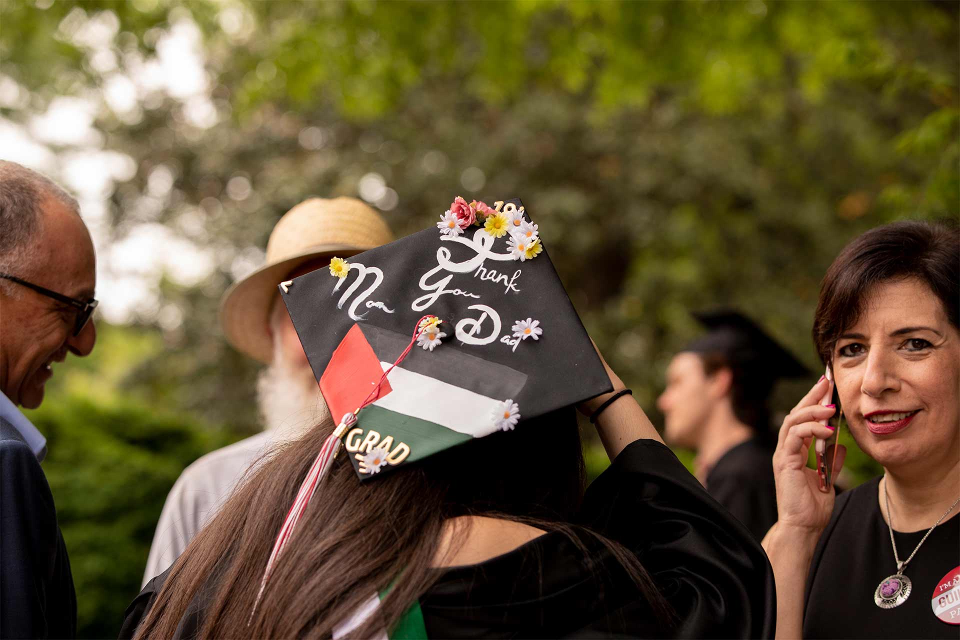 A student's mortarboard reads, "Thanks Mom and Dad!"