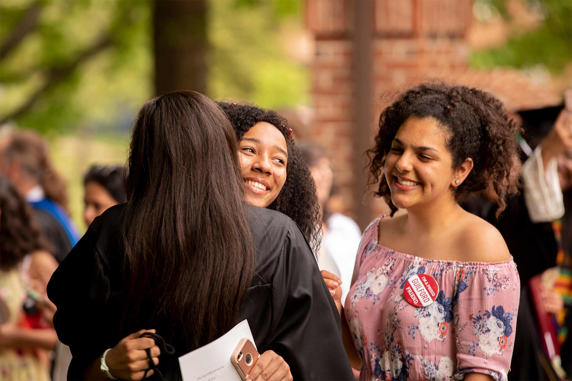 A graduate gets hugs of congratulations from friends after Commencement.