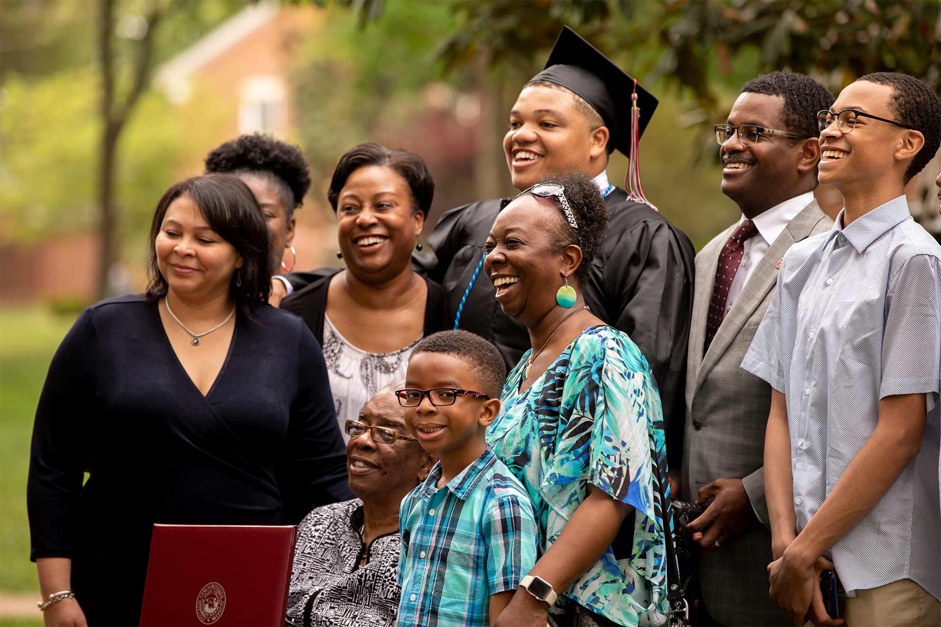 A family poses for a photo with their graduate after Commencement.