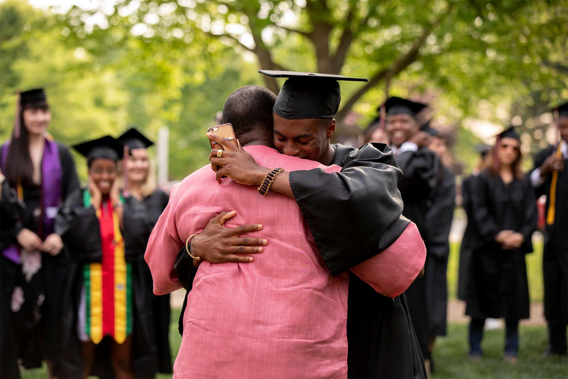 A student hugs a friend after Commencement.