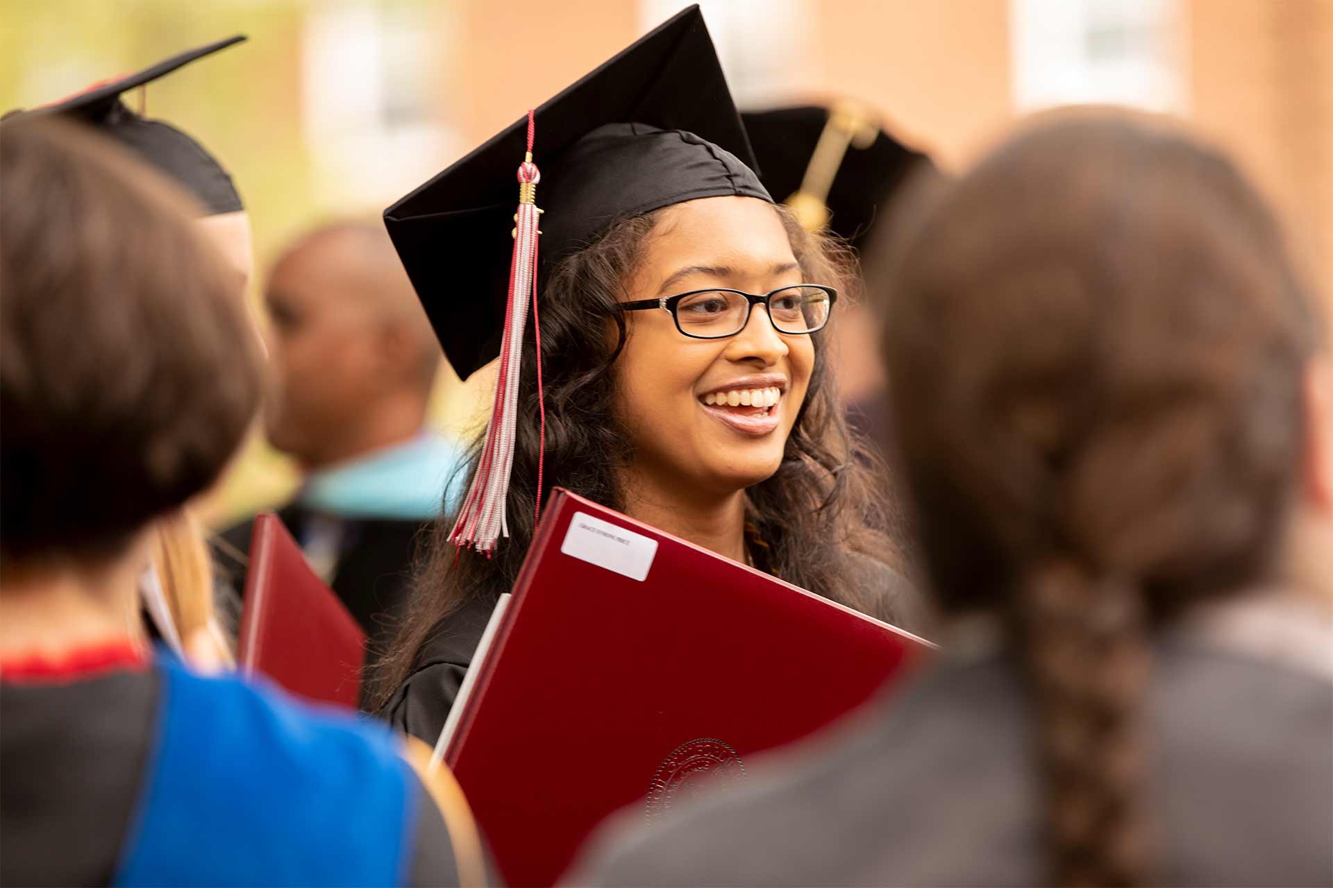 A student holds her diploma after Commencement.