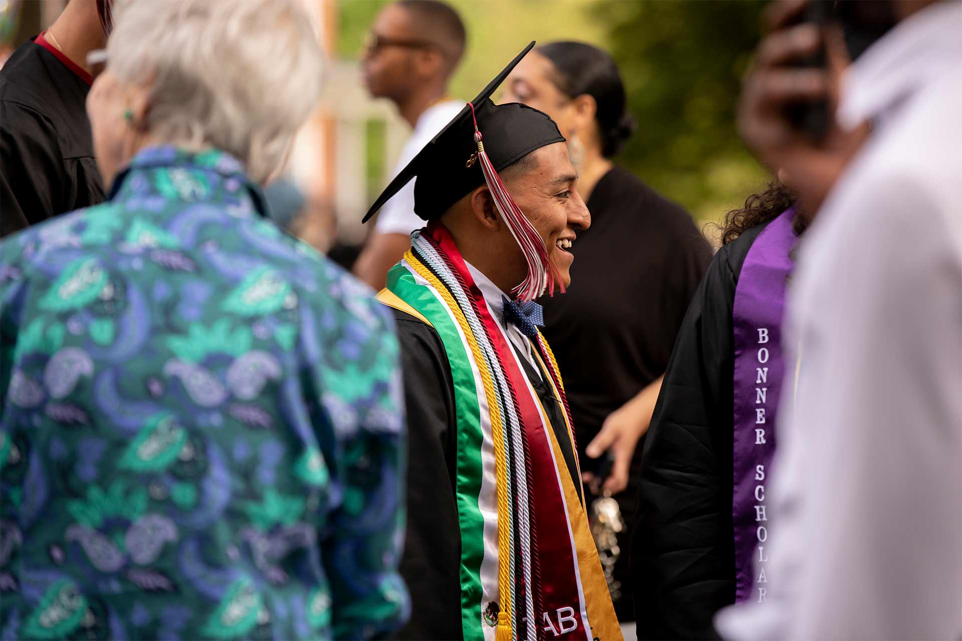 A 2018 graduate smiles at the crowd during Commencement.