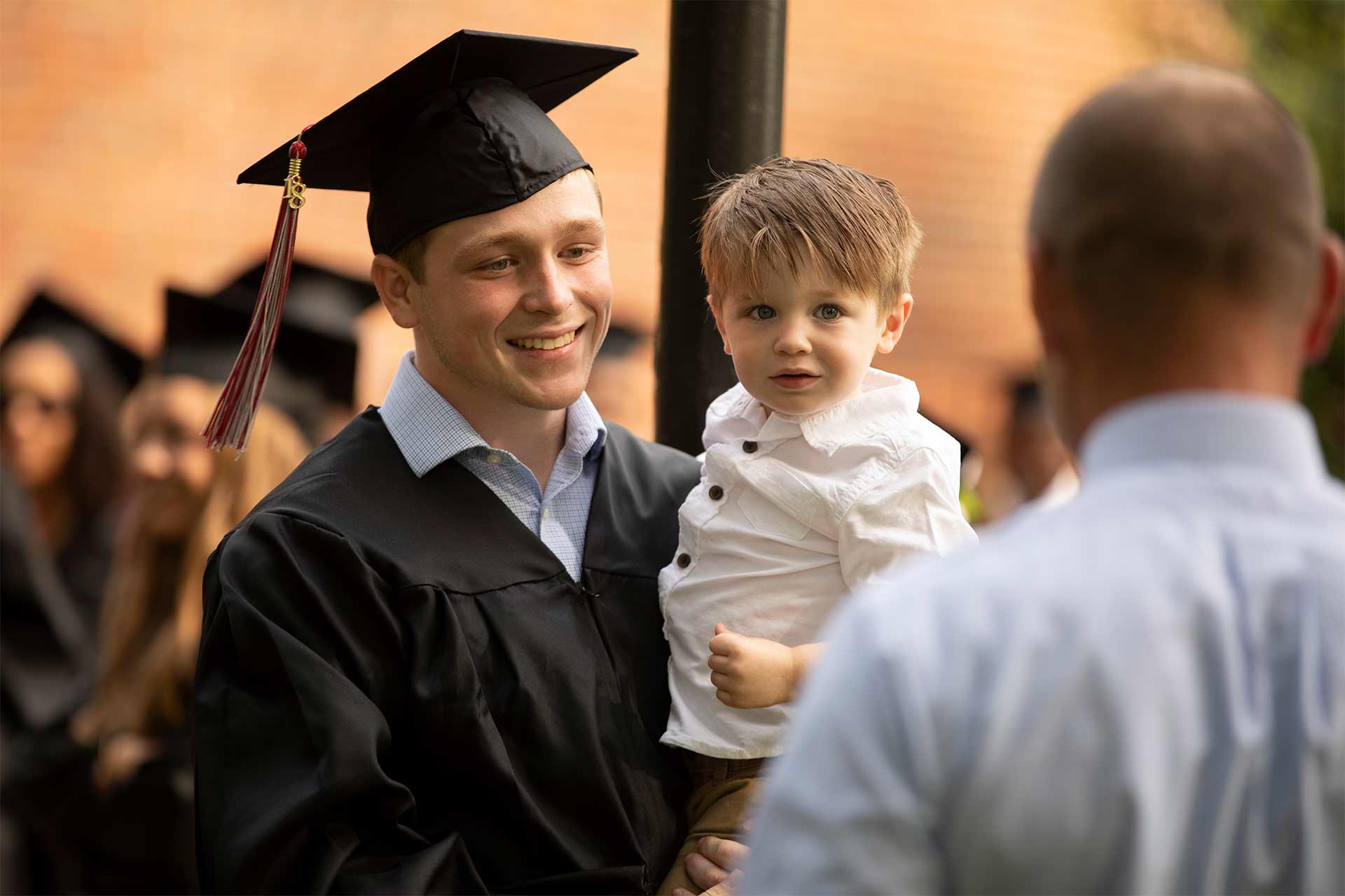 A graduate takes a photo at Commencement.