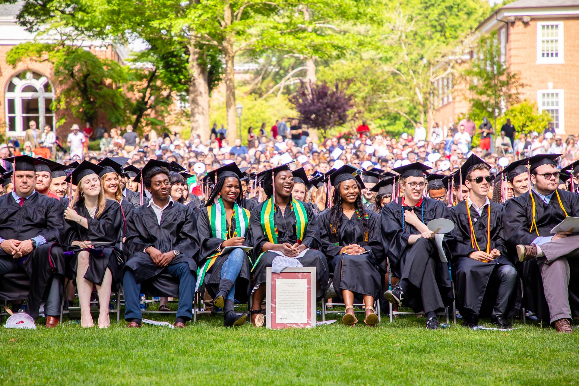 Graduating students sit together at Commencement.