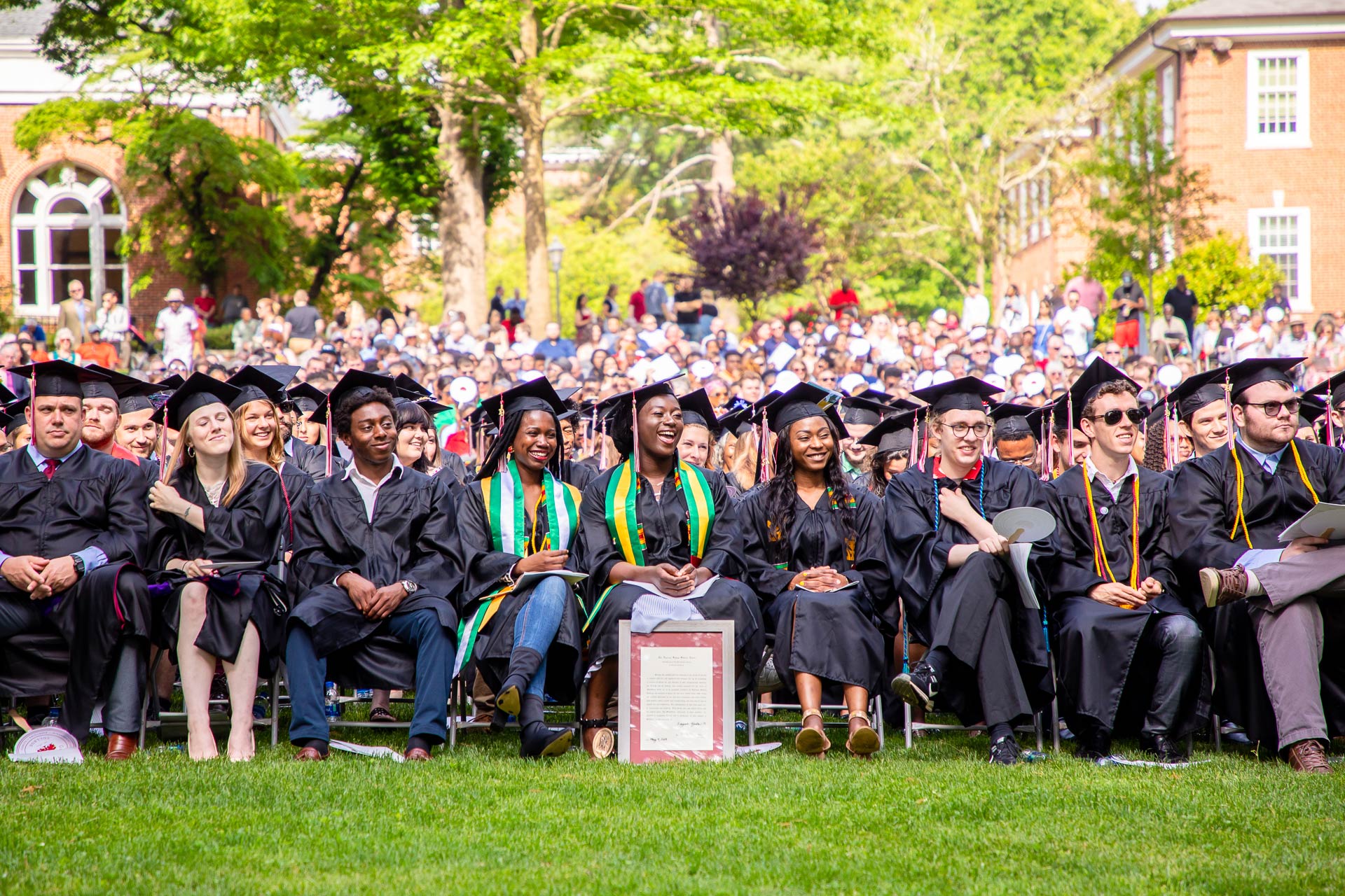 Graduating students sit together at Commencement.