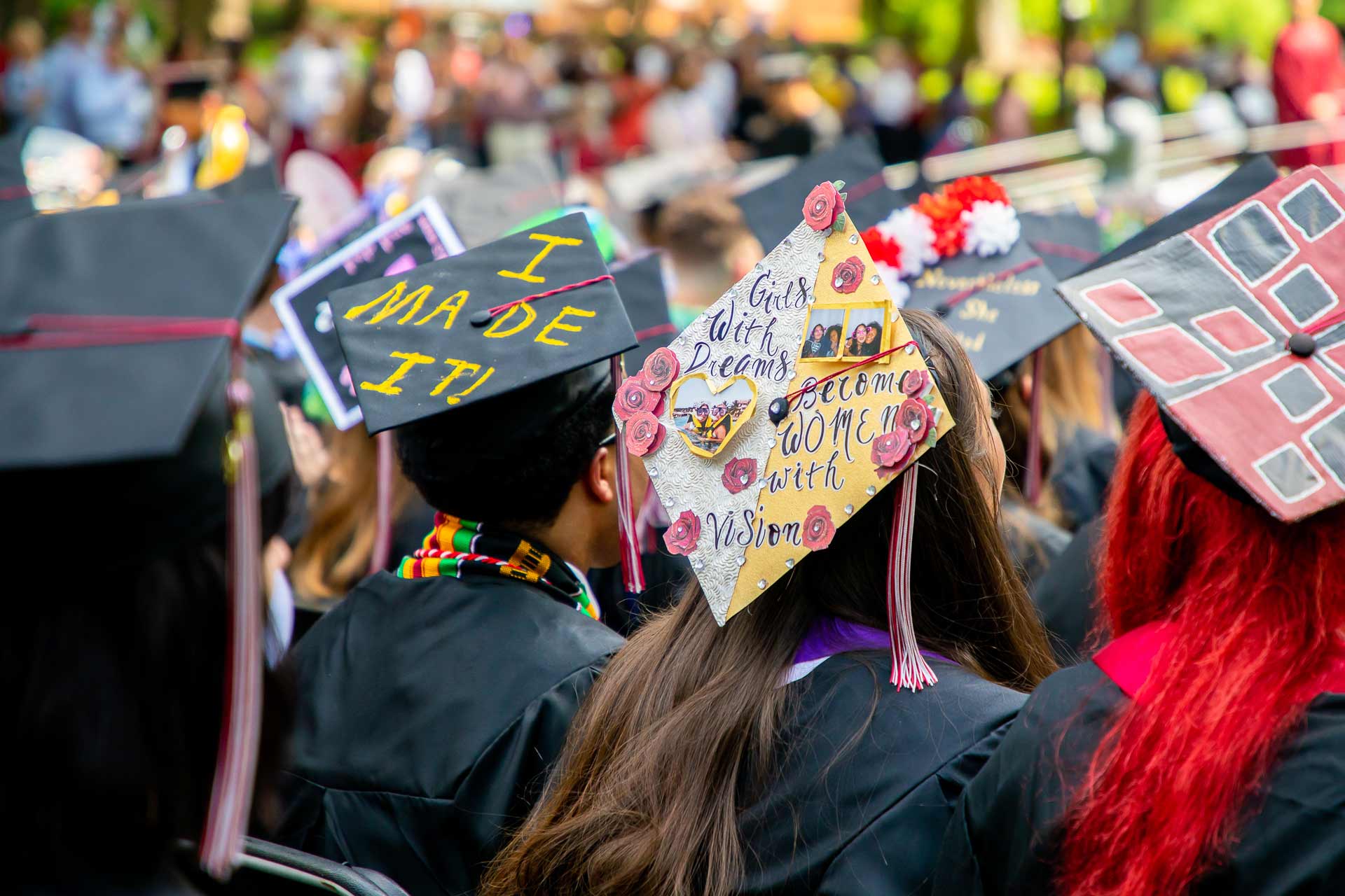 Students' mortar boards read, "I made it!" and "Girls with dreams become women with vision."