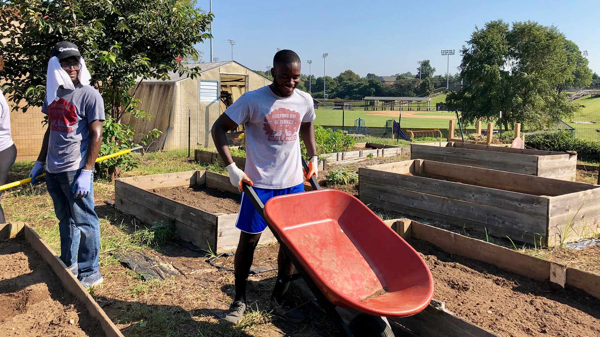 Students volunteer to do yard work at Newcomers School on Day of Service.