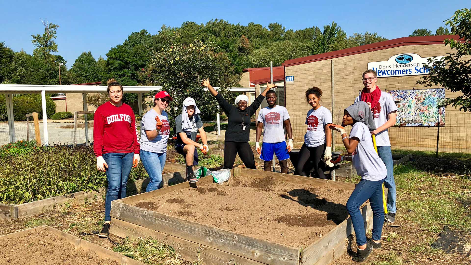 Students volunteer to do yard work at Newcomers School on Day of Service.