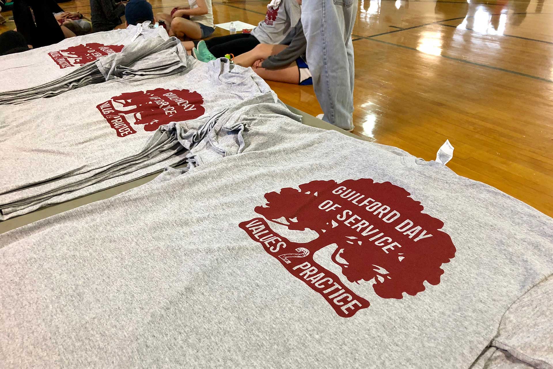 Day of Service t-shirts are piled up for students to take.