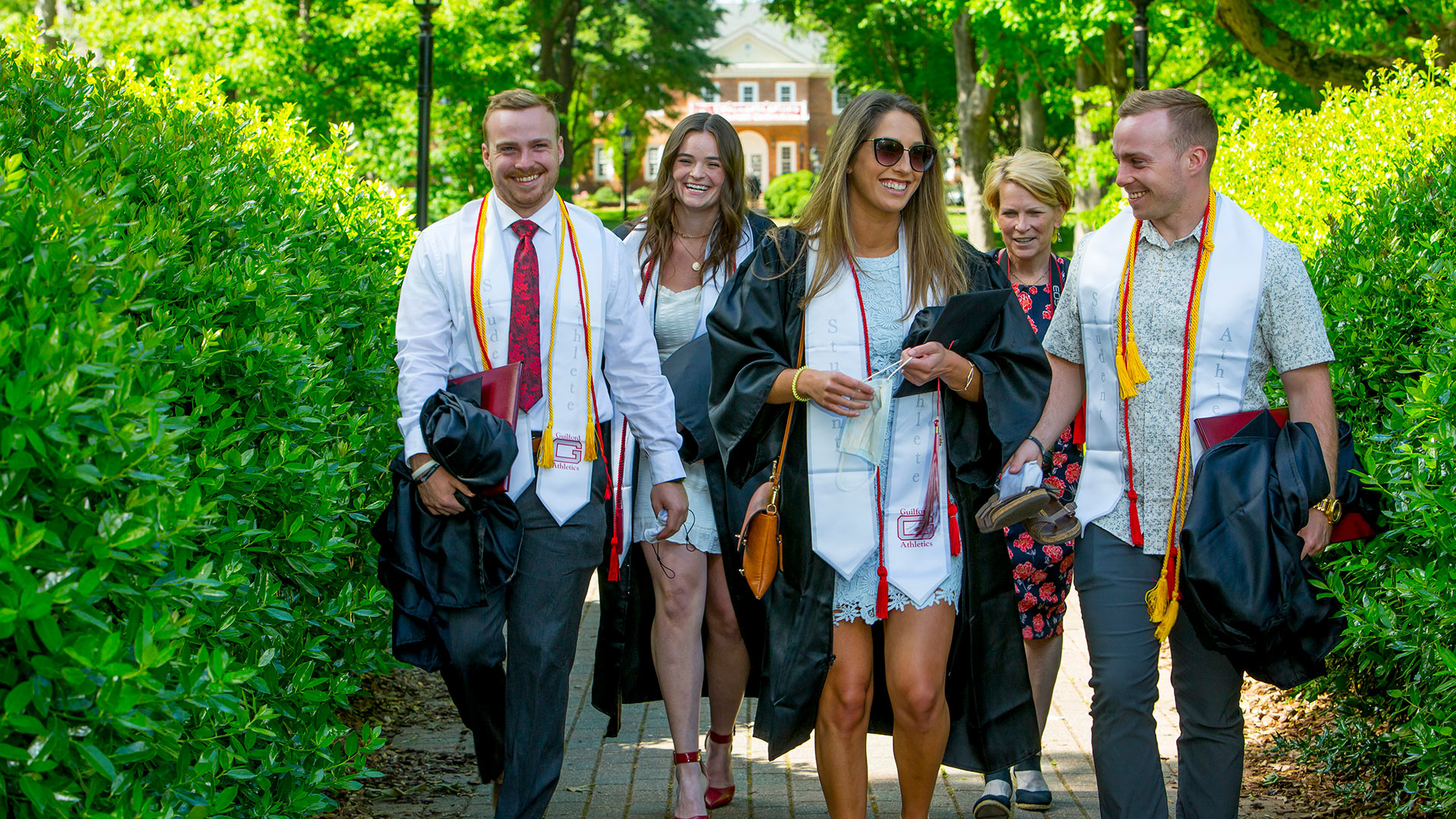 Graduating student athletes walk together across the Quad.