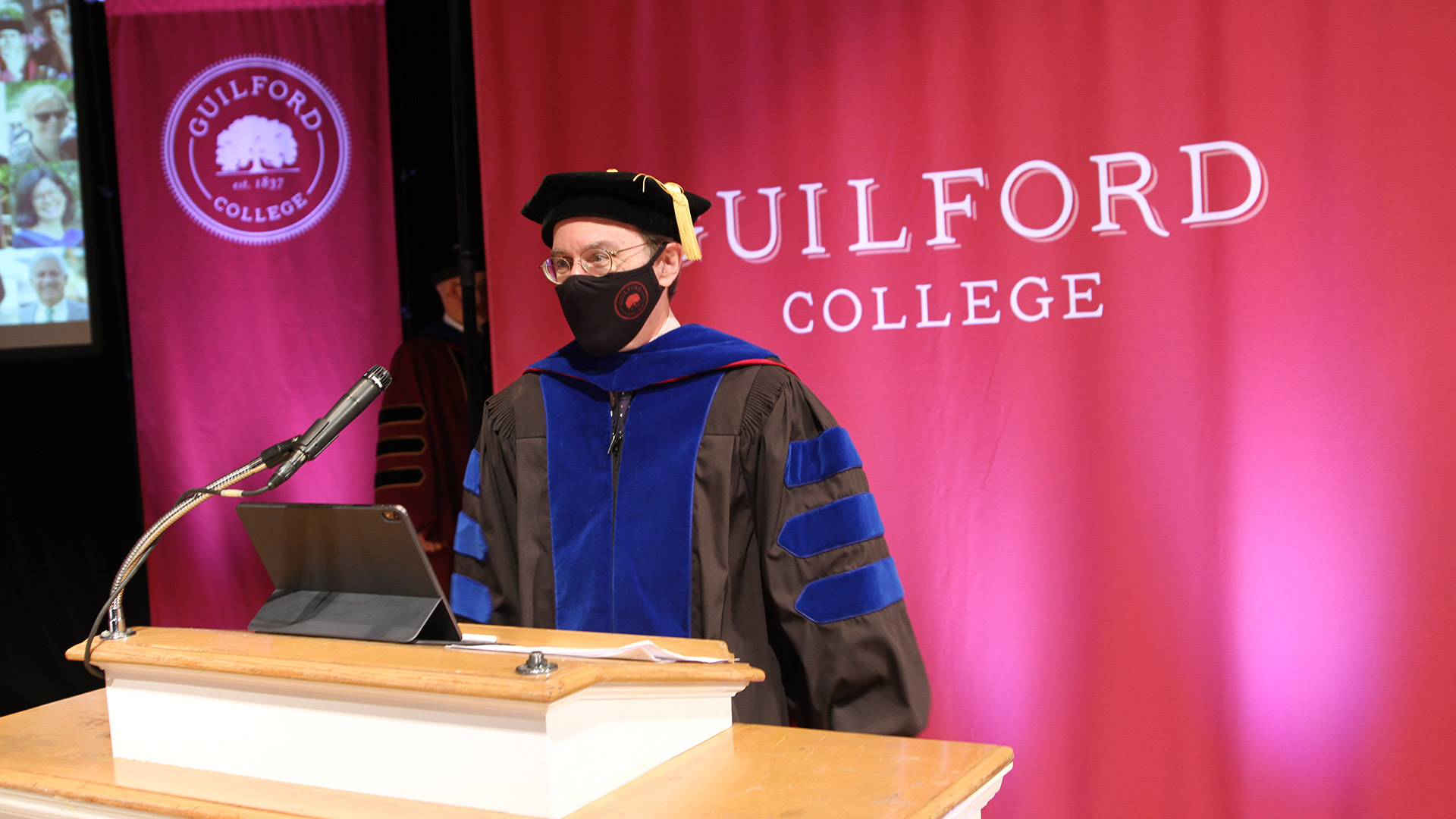 Provost Rob Whitnell reads names as graduates walk across the stage at Commencement 2020.
