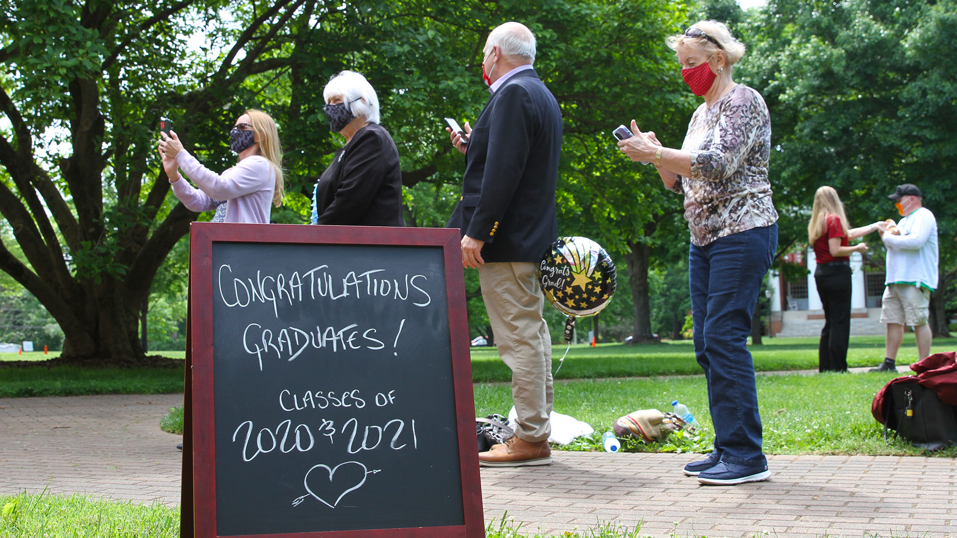 Relatives line the sidewalk in front of Dana Auditorium at Commencement 2020.
