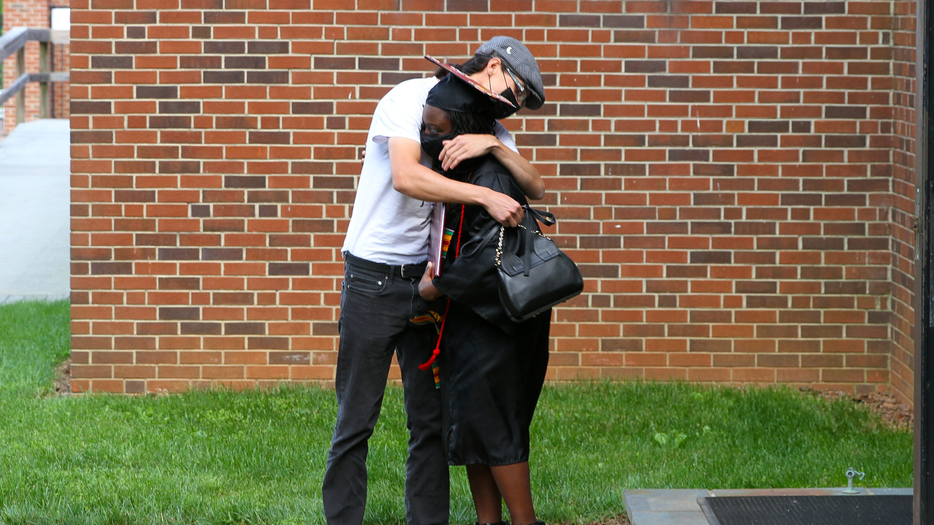 A friend embraces a graduate outside after Commencement 2020.