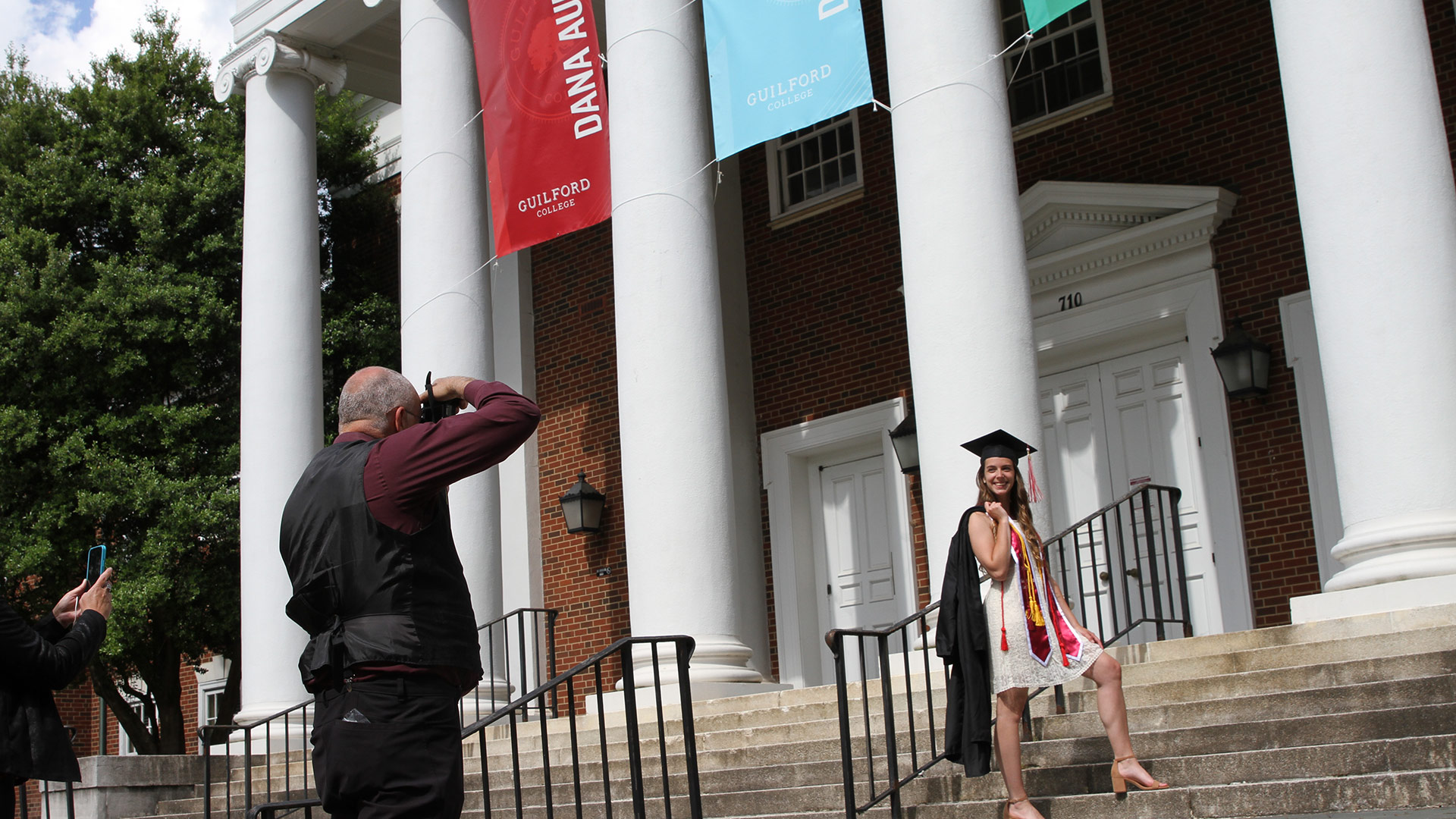 Dana Auditorium serves as the perfect collegiate backdrop for this student to take a photo after Commencement 2020.