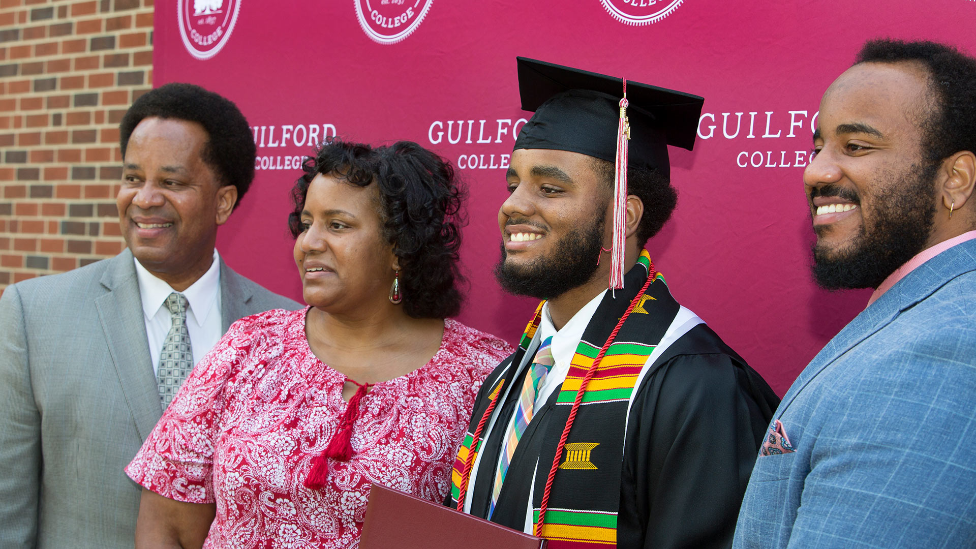 A graduate takes a photo with family members.
