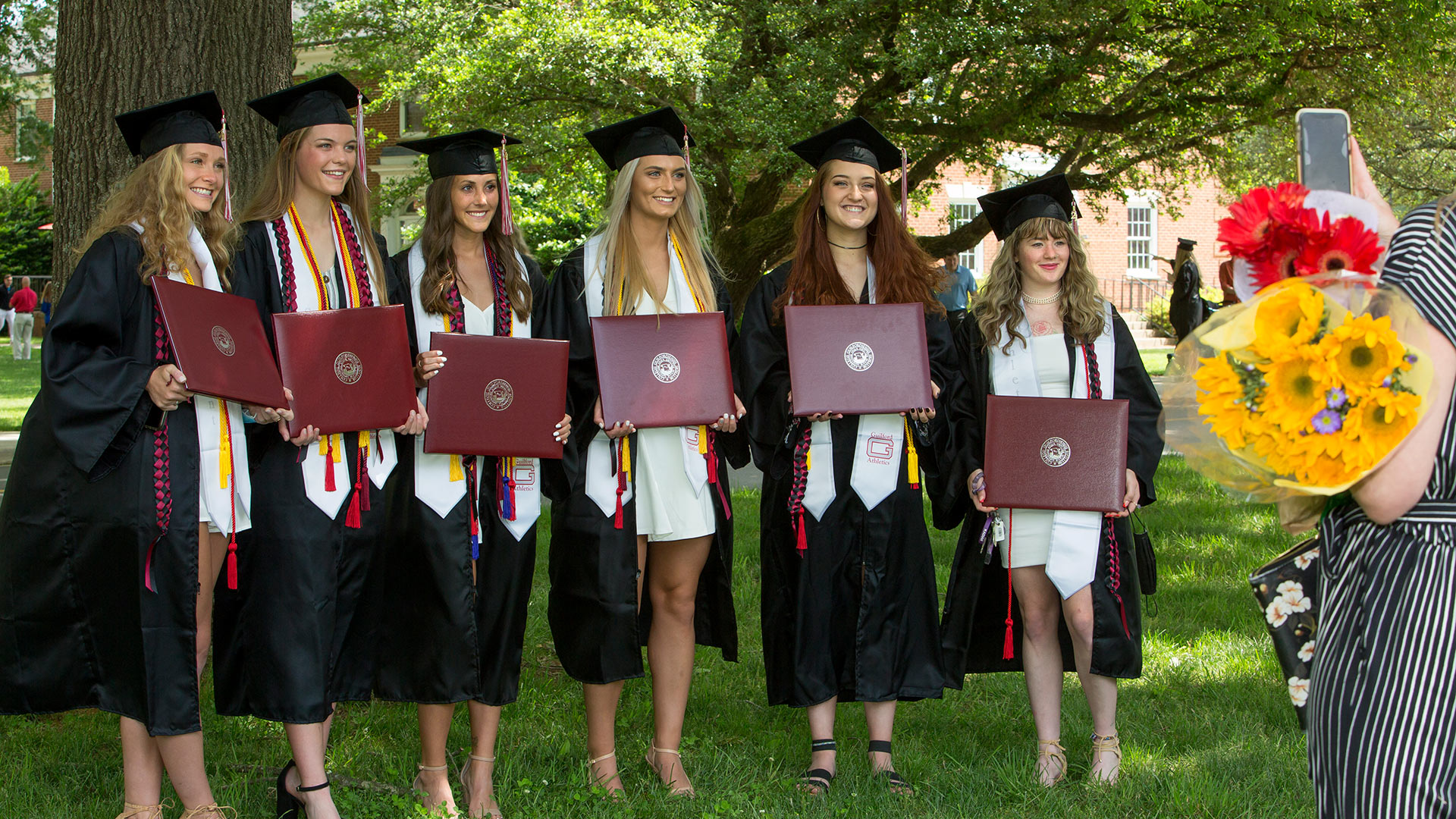 A group of students pose to take a photo together at Commencement.