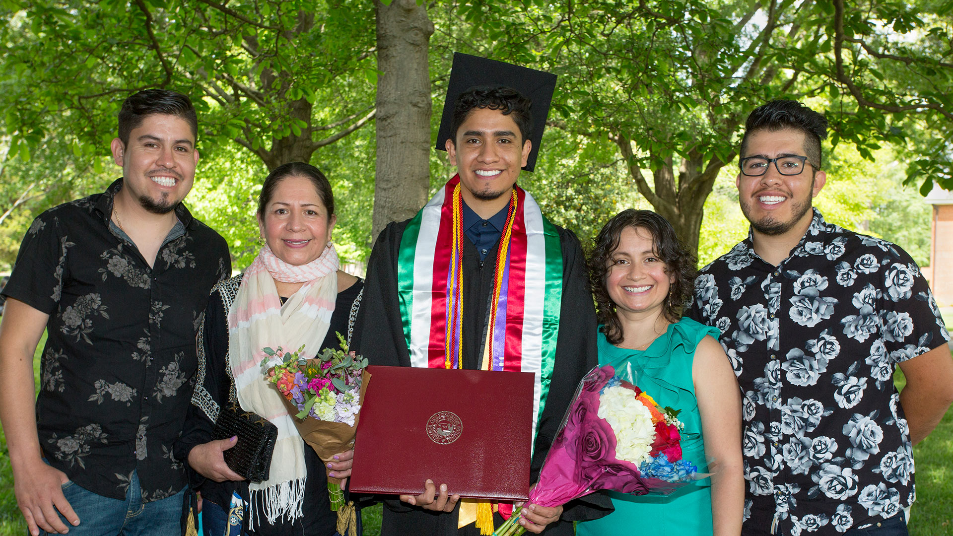 A family and its graduate take a photo together on the Quad.