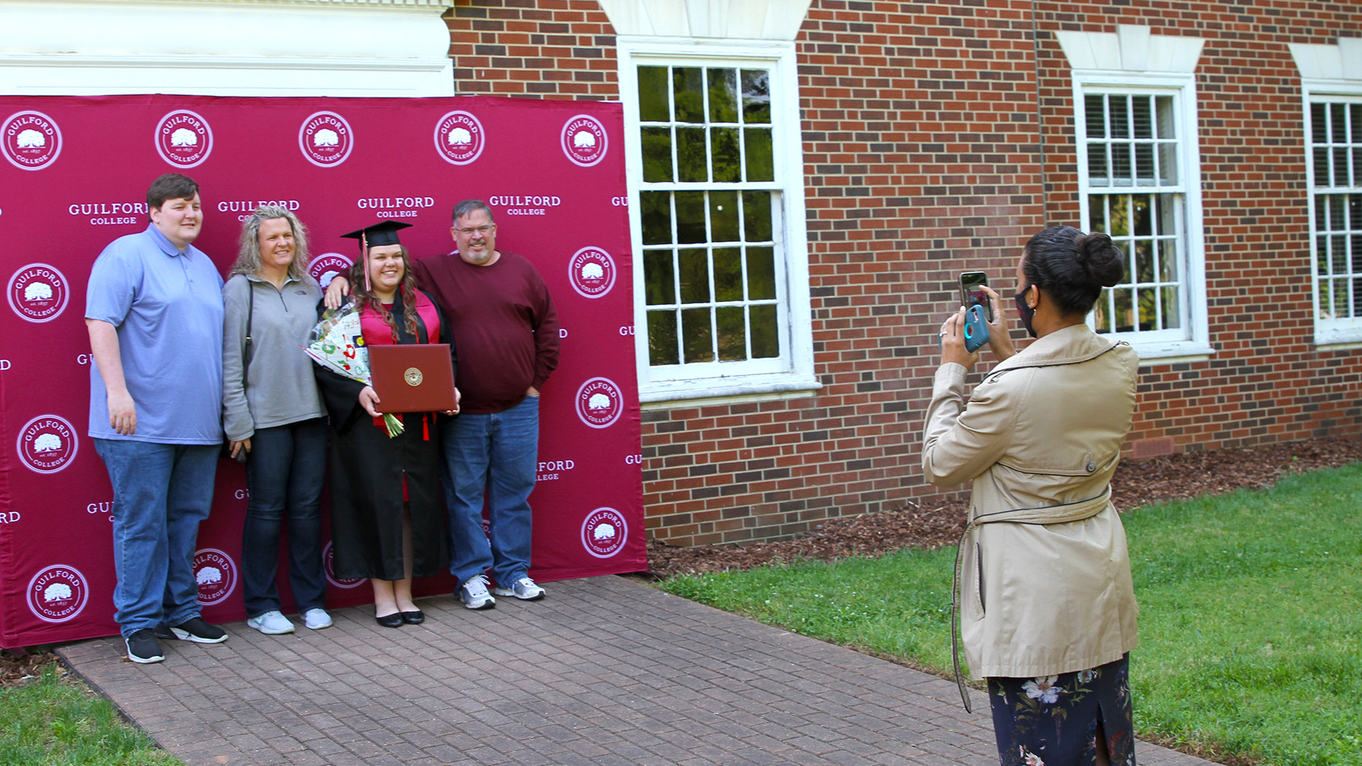 Staff member Stephanie Davis helps families get that perfect shot in front of a backdrop at Commencement 2021.