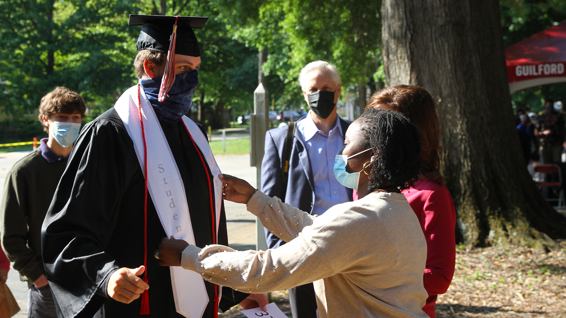 A friend gives a graduate a few final touches before taking the stage for Commencement 2021.