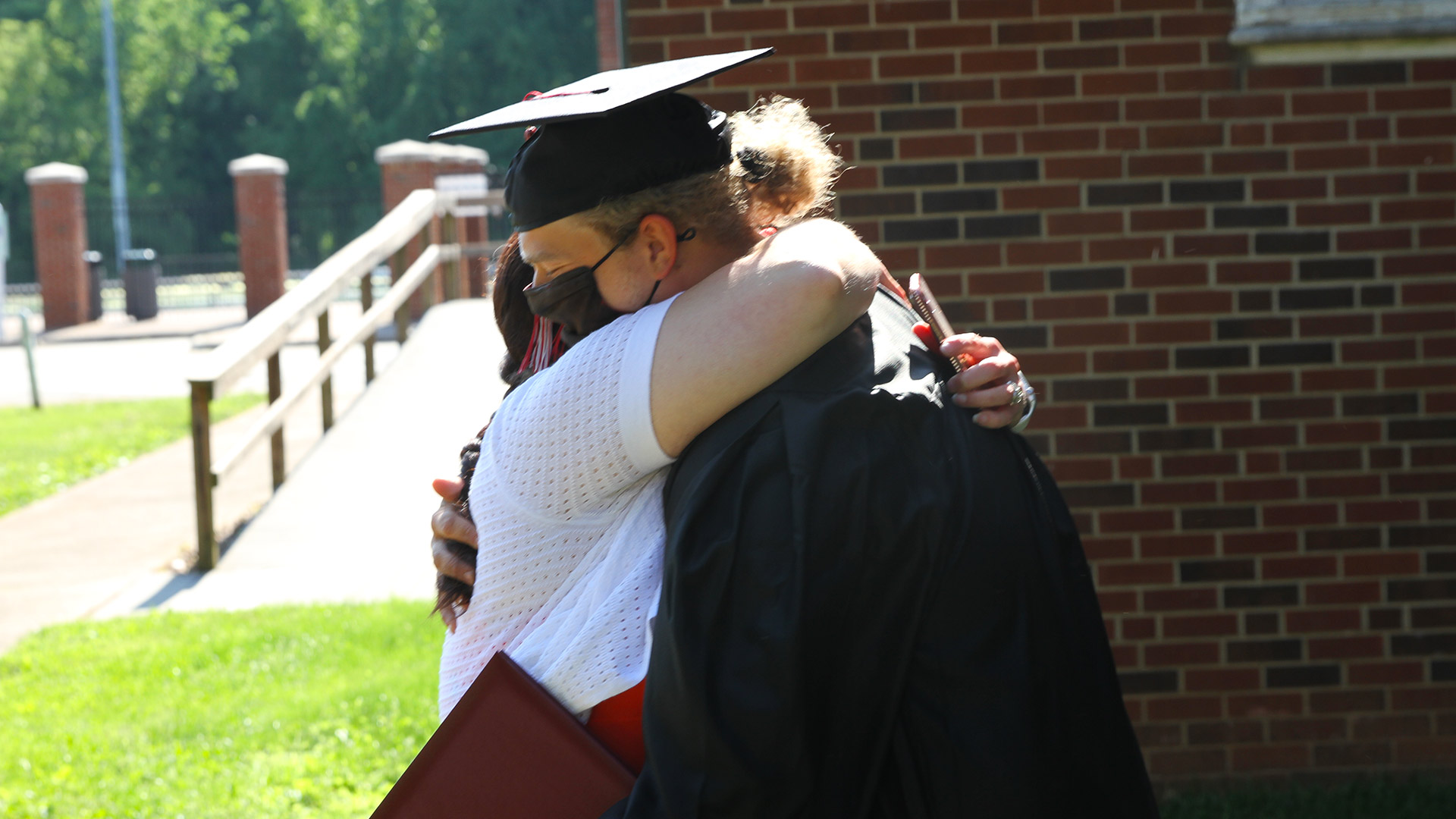 A student hugs a friend after Commencement 2021.