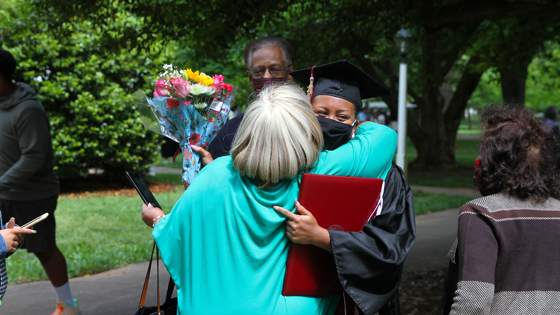 A 2021 graduates gives out hugs after Commencement.