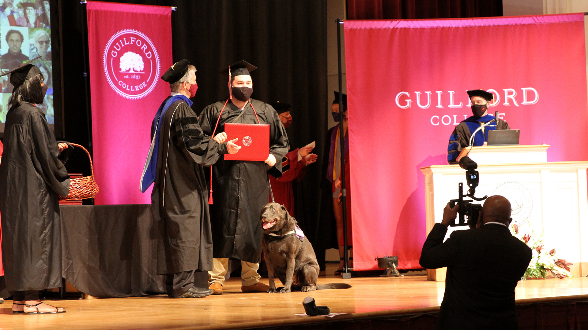 A student receives their diploma on stage in Dana Auditorium.