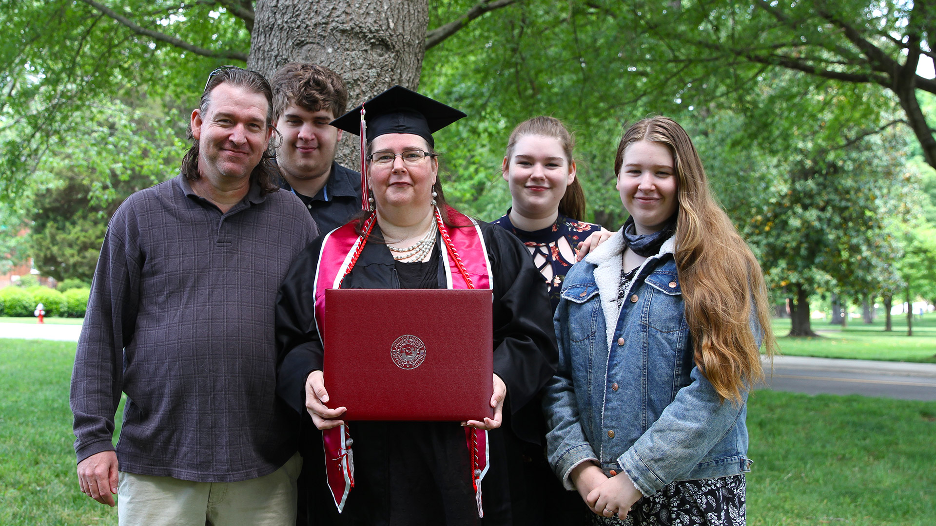 A family takes a photo with a 2021 graduate after Commencement.