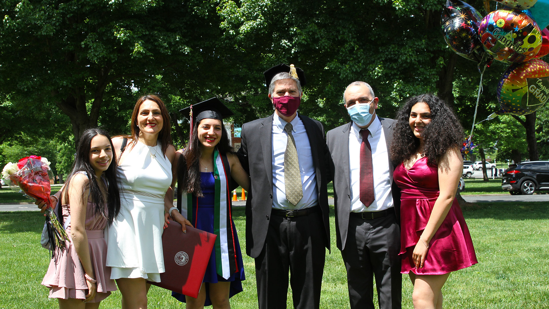A family and a graduate takes a photo with President Jim Hood '79.