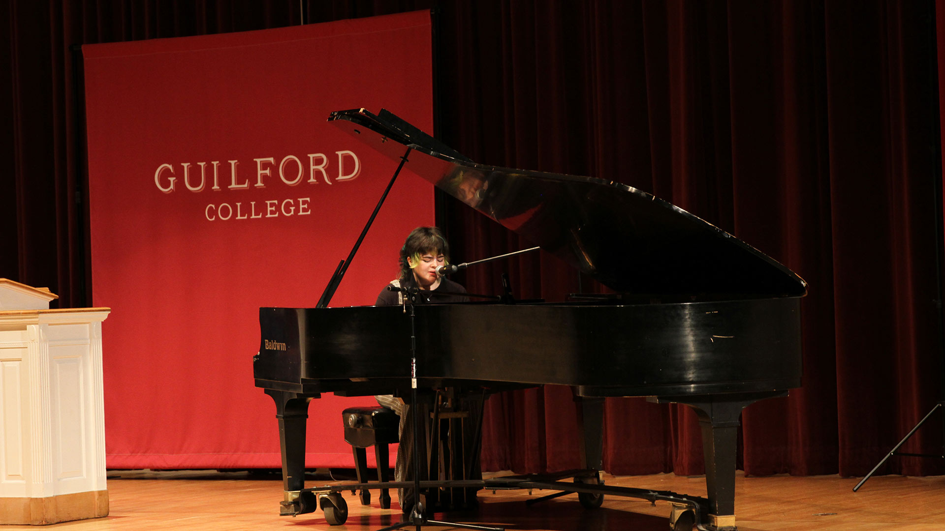 Student Lexi McGraw '24 sits at the piano to sing and play.