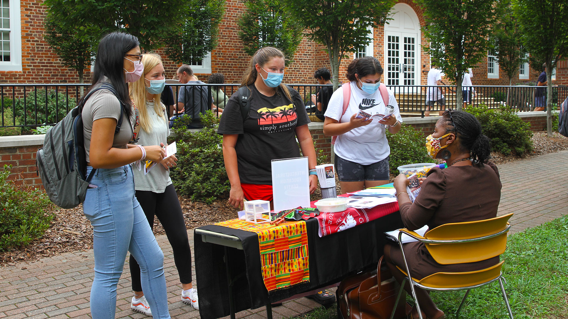 Three students stop by to speak with a staff member from the Intercultural Engagement Center.