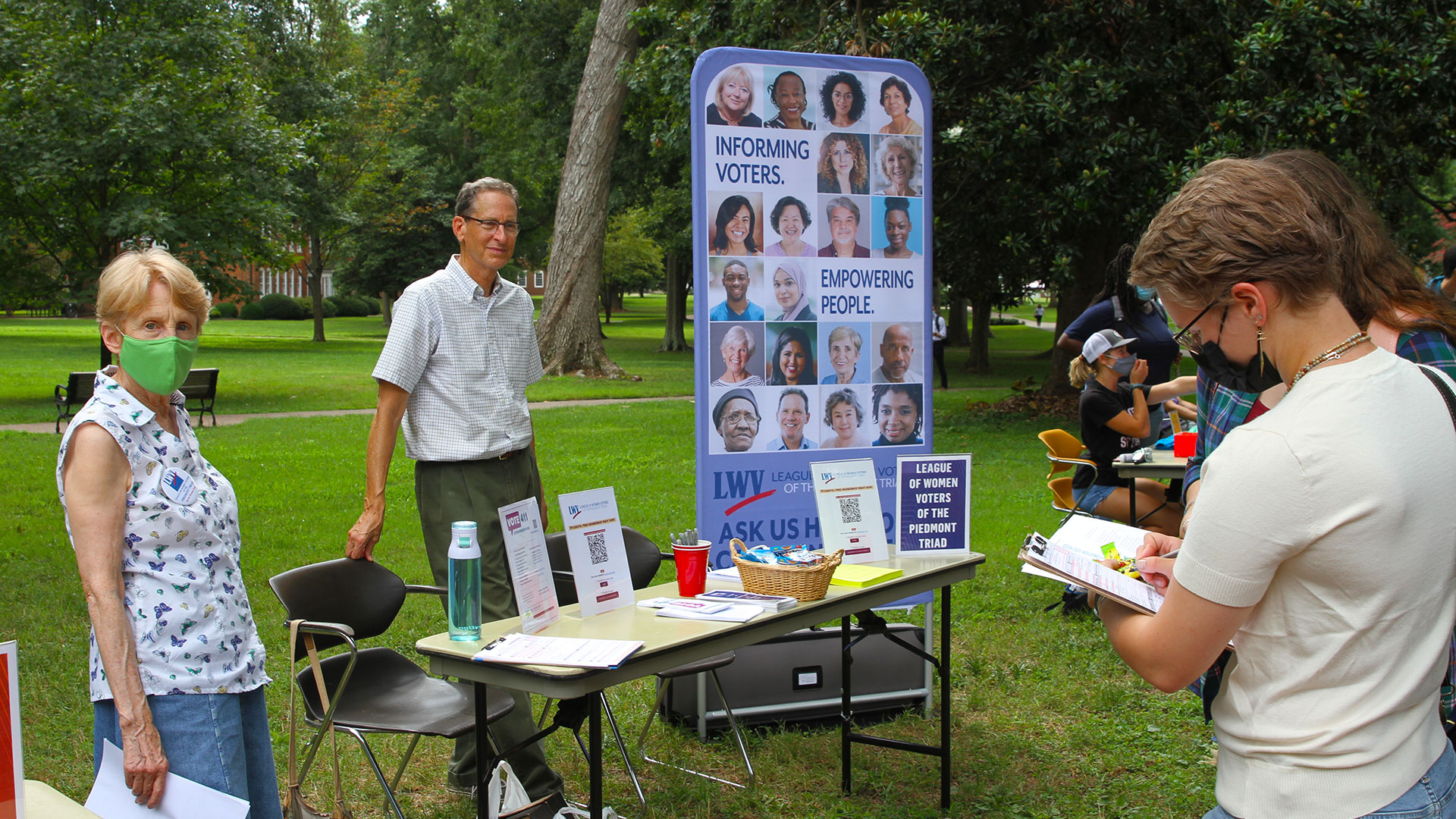A student visits a table set up by the League of Women Voters of the Piedmont Triad.