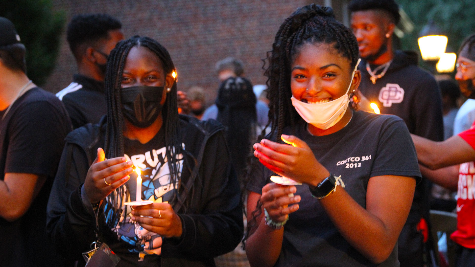 Two students hold their lit candles at the Passing of the Light ceremony.