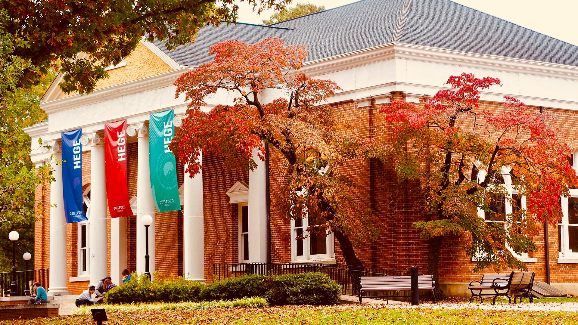 Trees with red leaves flank Hege Library on Guilford's campus. (Mei Lander Photo)