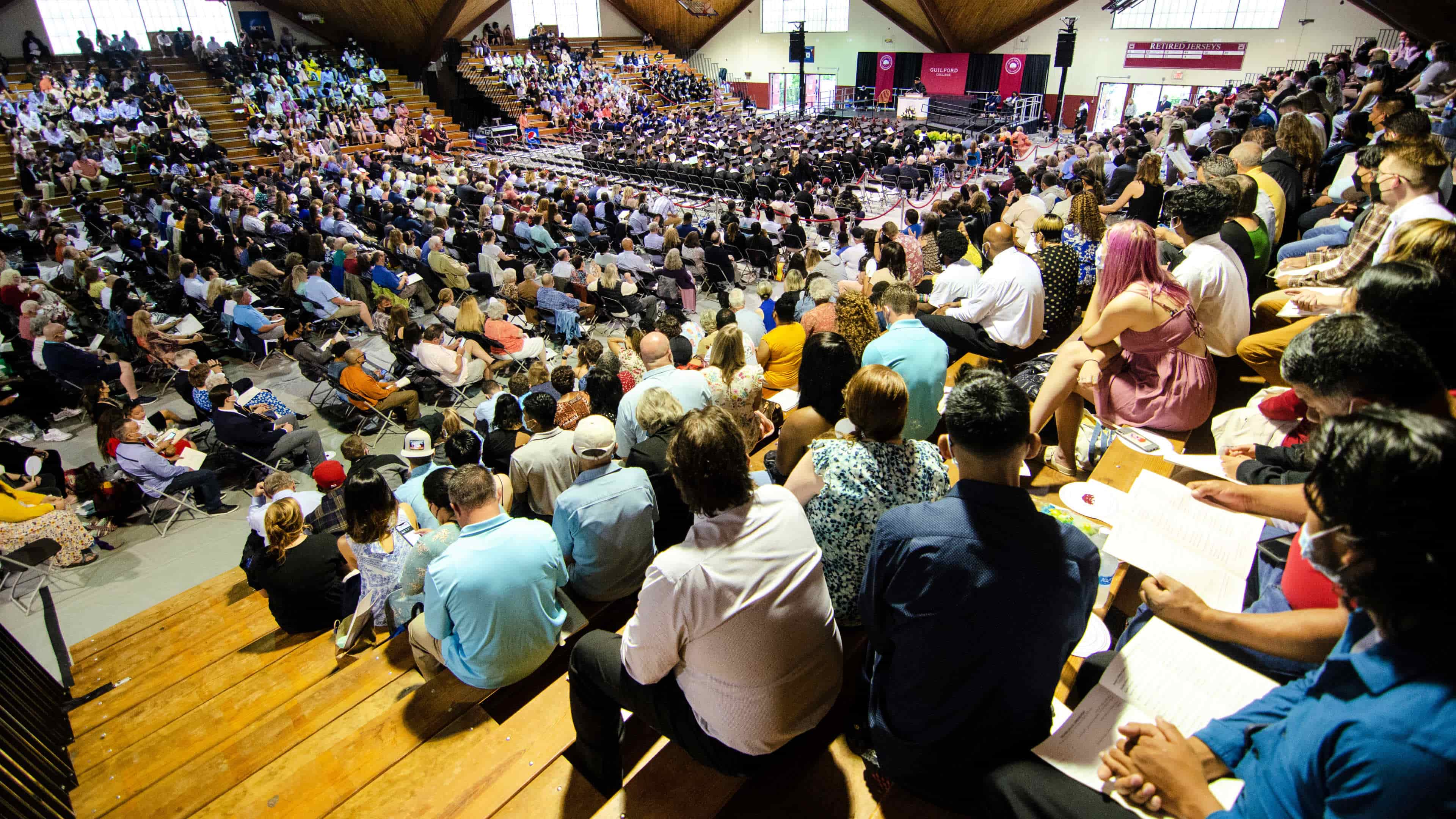 Guests fill the bleachers in Ragan-Brown Gym as graduating students fill the floor seats at Commencement.