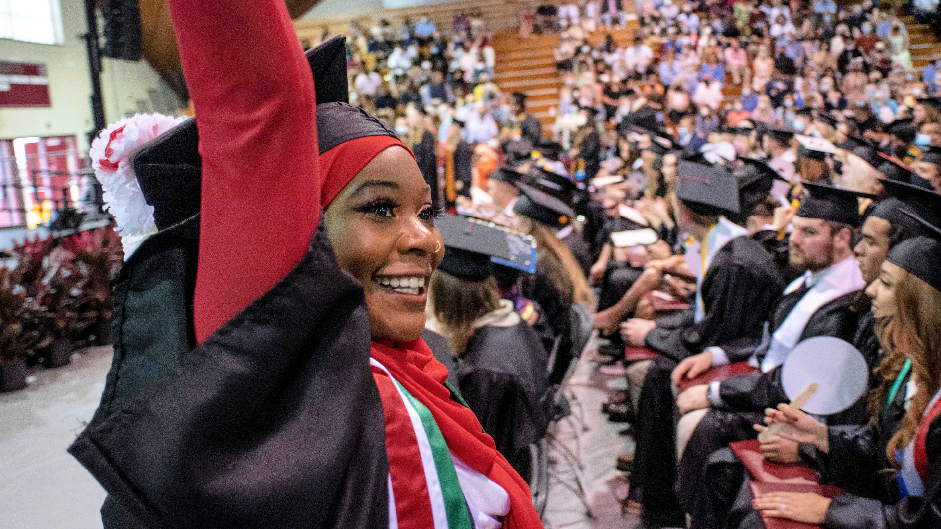 A student waves to the crowd after receiving their diploma.