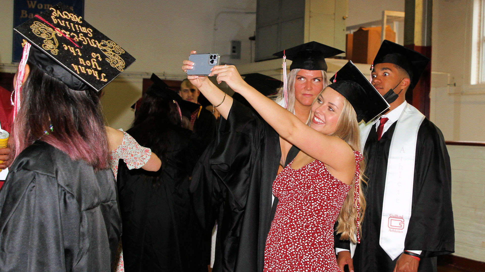 Three students take a group selfie before Commencement.