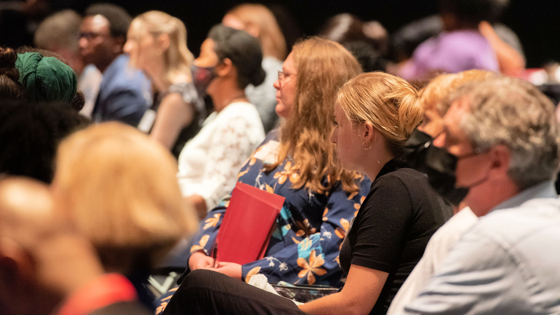 Attendees fill seats in the auditorium, listening intently, at the Guilford Dialogues.