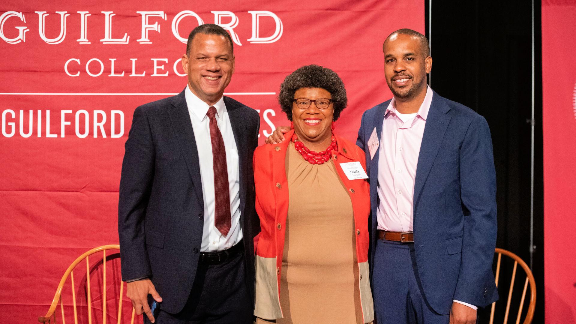 President Kyle Farmbry stands with two guests in front of the Guilford Dialogues backdrop.