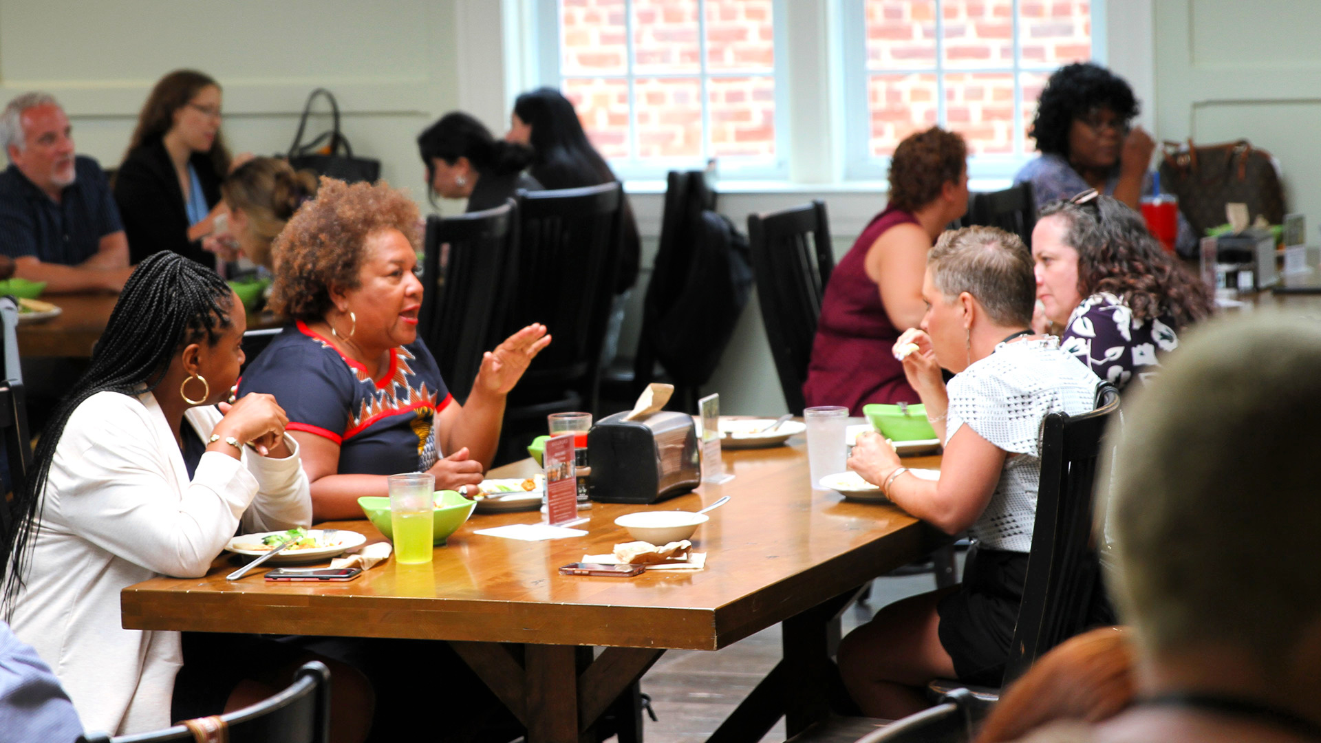 Attendees chat at tables during lunch in the Dining Hall at the Guilford Dialogues.