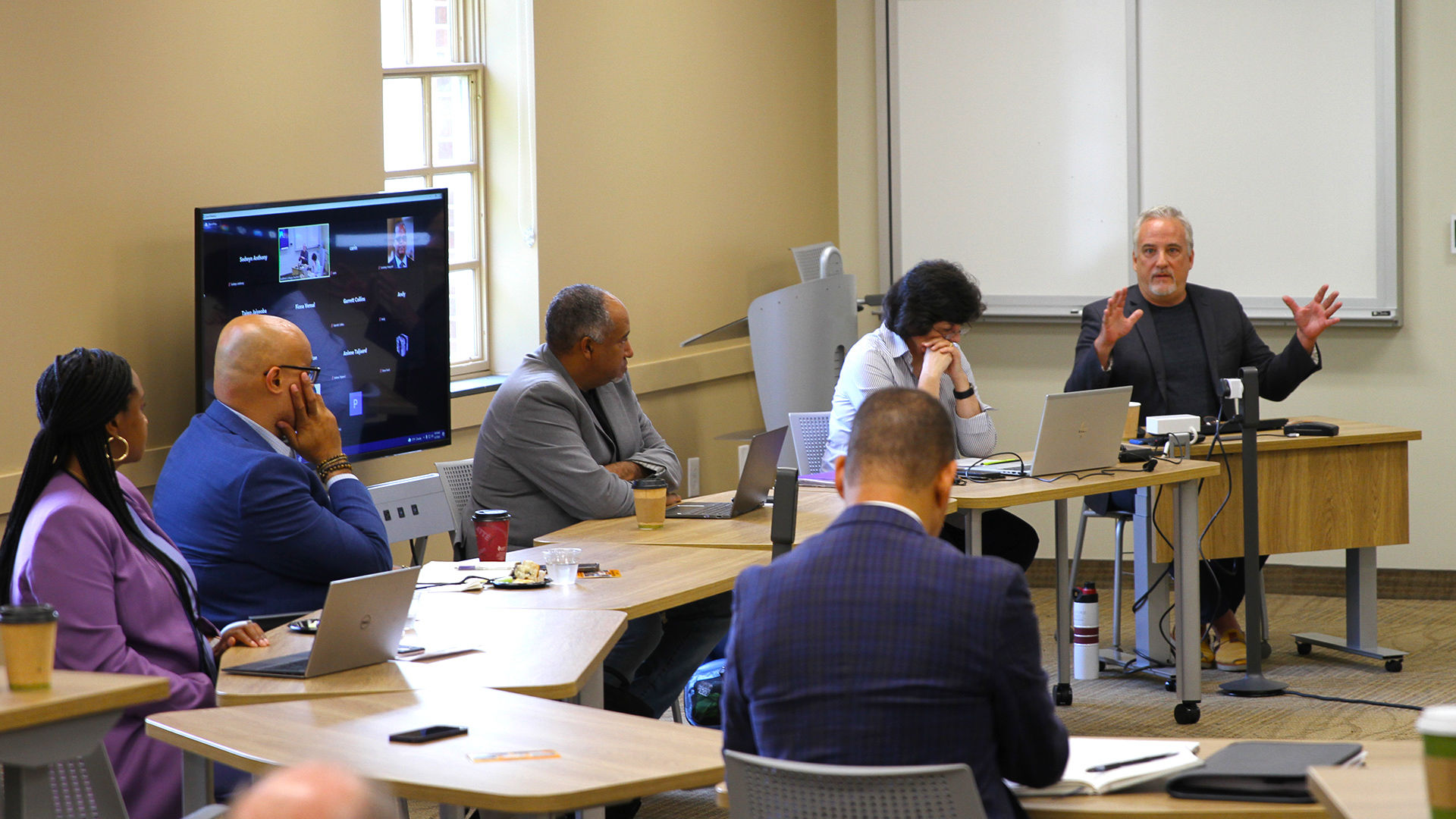 Tim Raphael speaks to a group seated in a circle during pre-forum activities at the Guilford Dialogues.