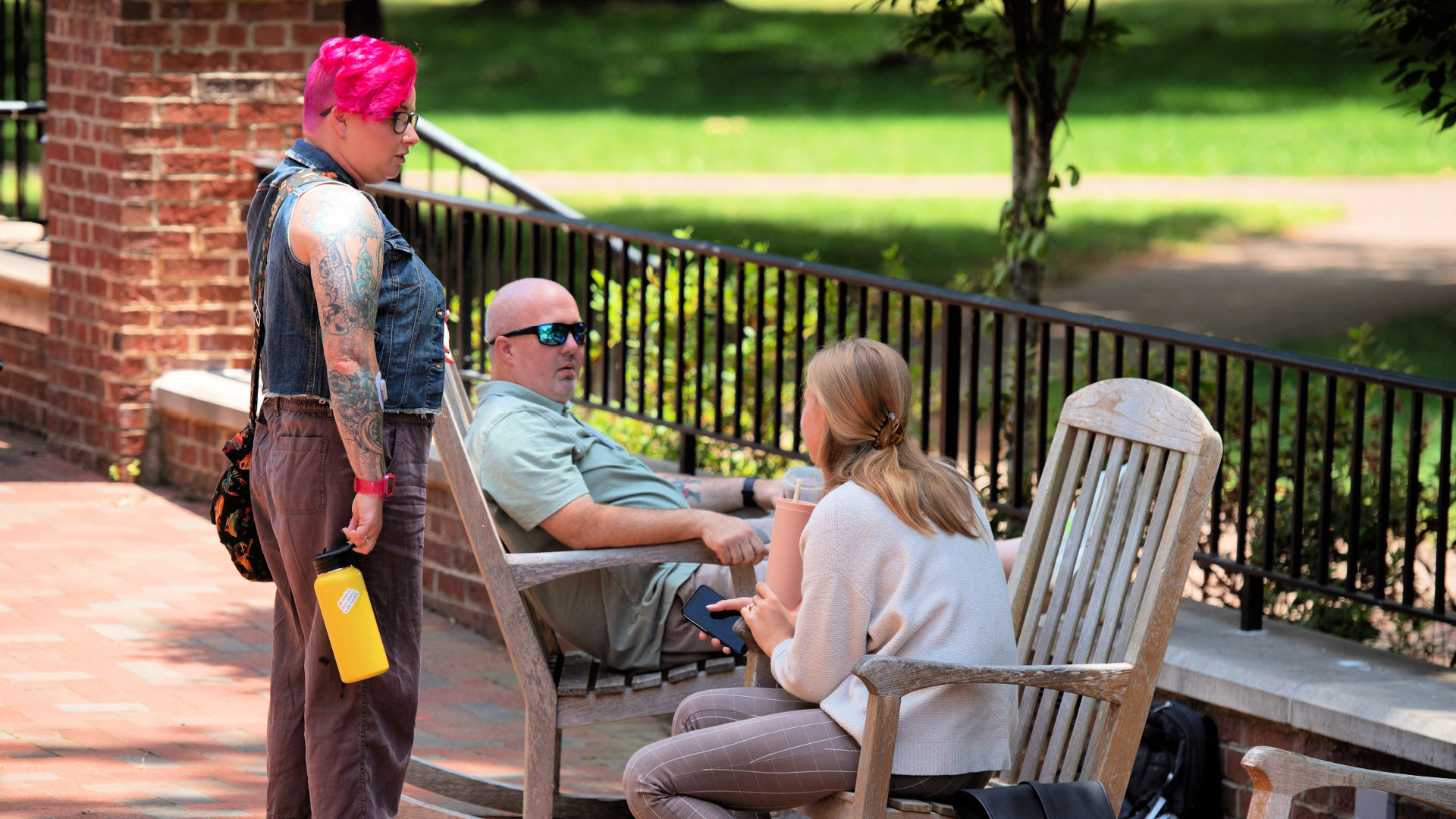 Attendees sit and chat in chairs on Founders Hall Patio at the Guilford Dialogues.