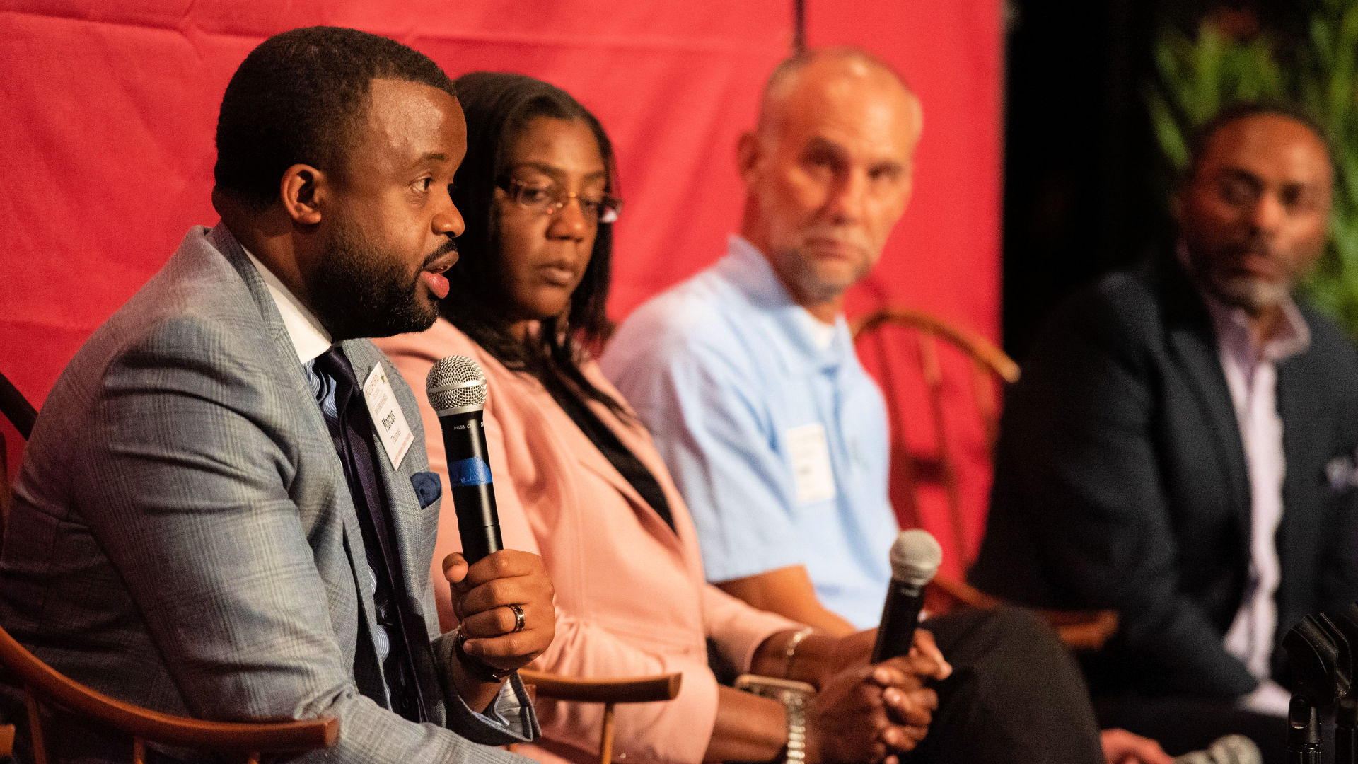 On stage at the Guilford Dialogues, seated in chairs, from left: Marcus Thomas, Josie Williams '16, Gene Brown, and David Hopkins '91.