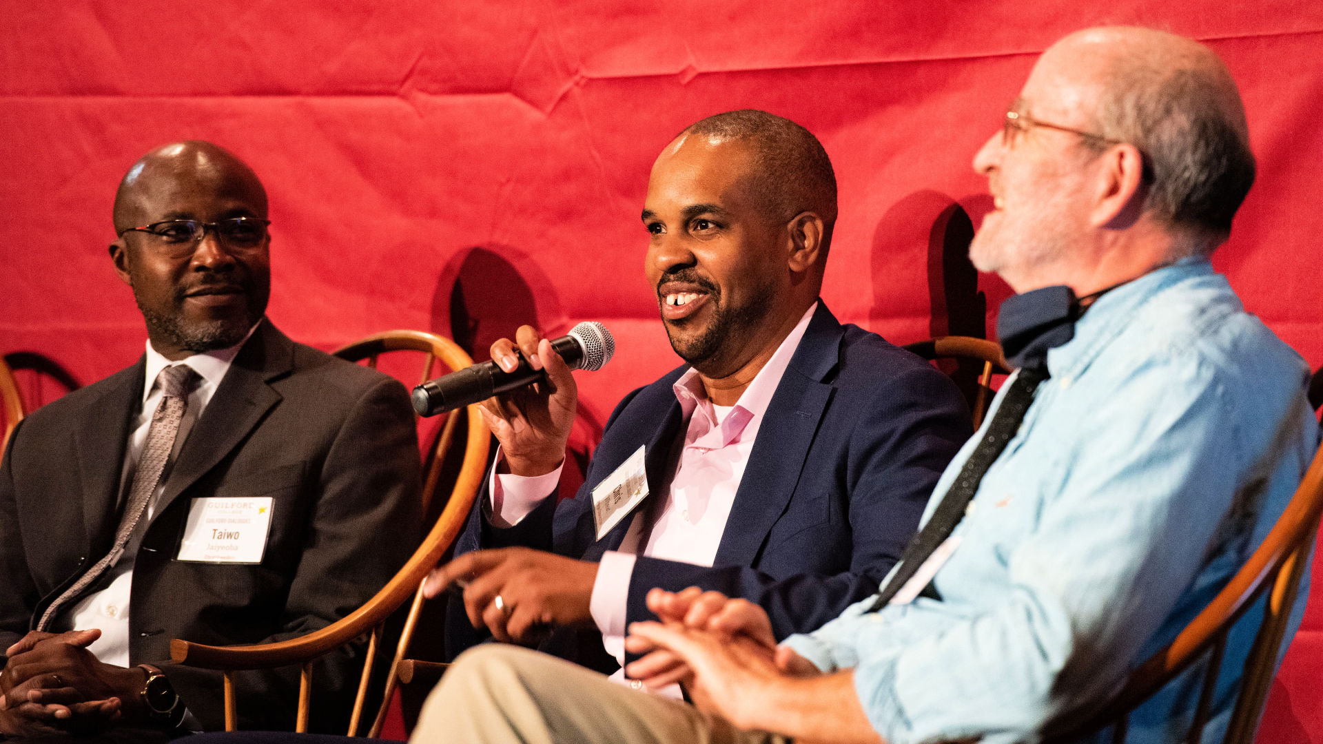 Seated on stage from left at the Guilford Dialogues are: Taiwo Jaiyeoba, Chris Wheat, and Bob Williams.