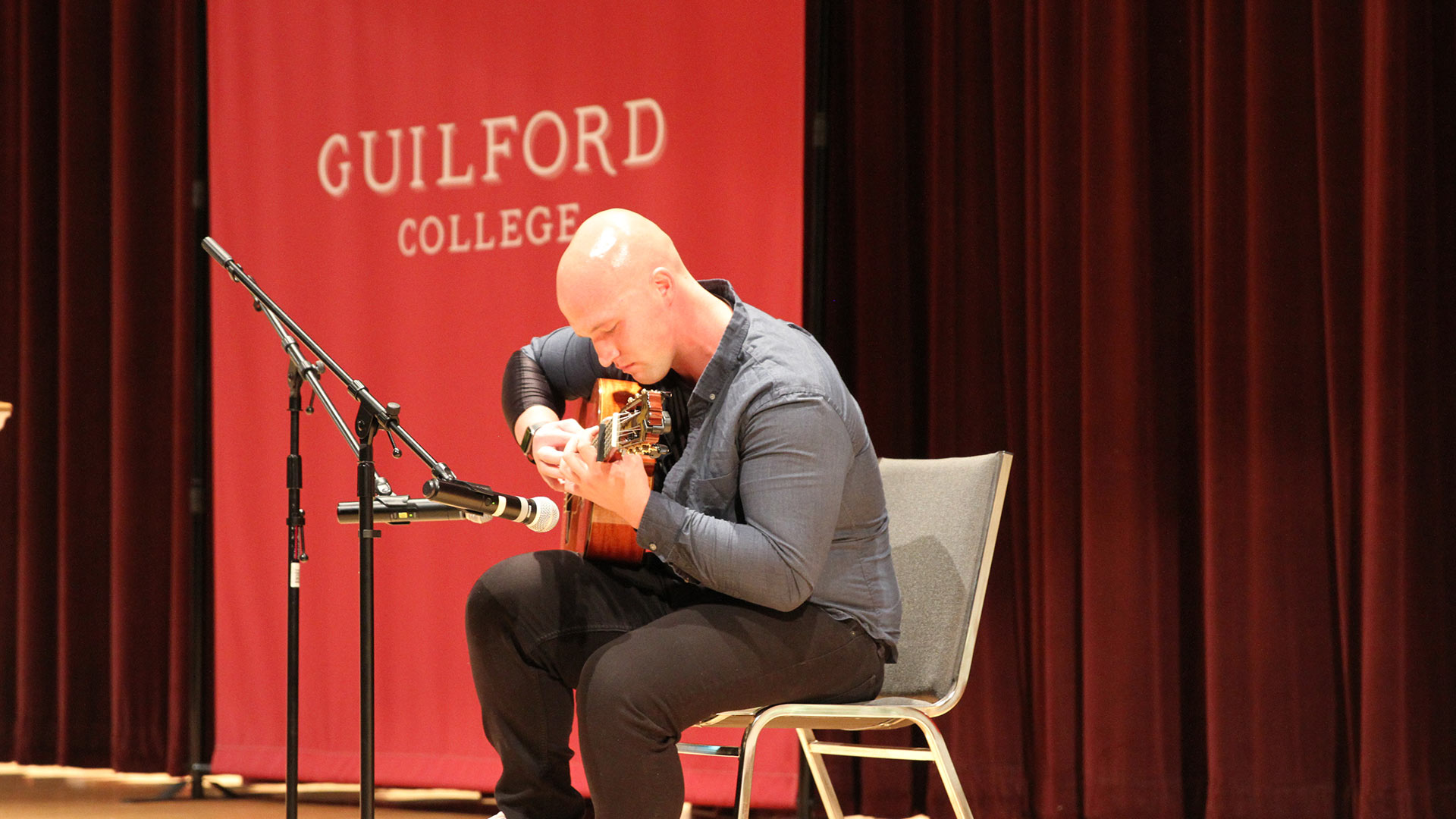 Noah Dabney ’23 plays the guitar on stage at Convocation.