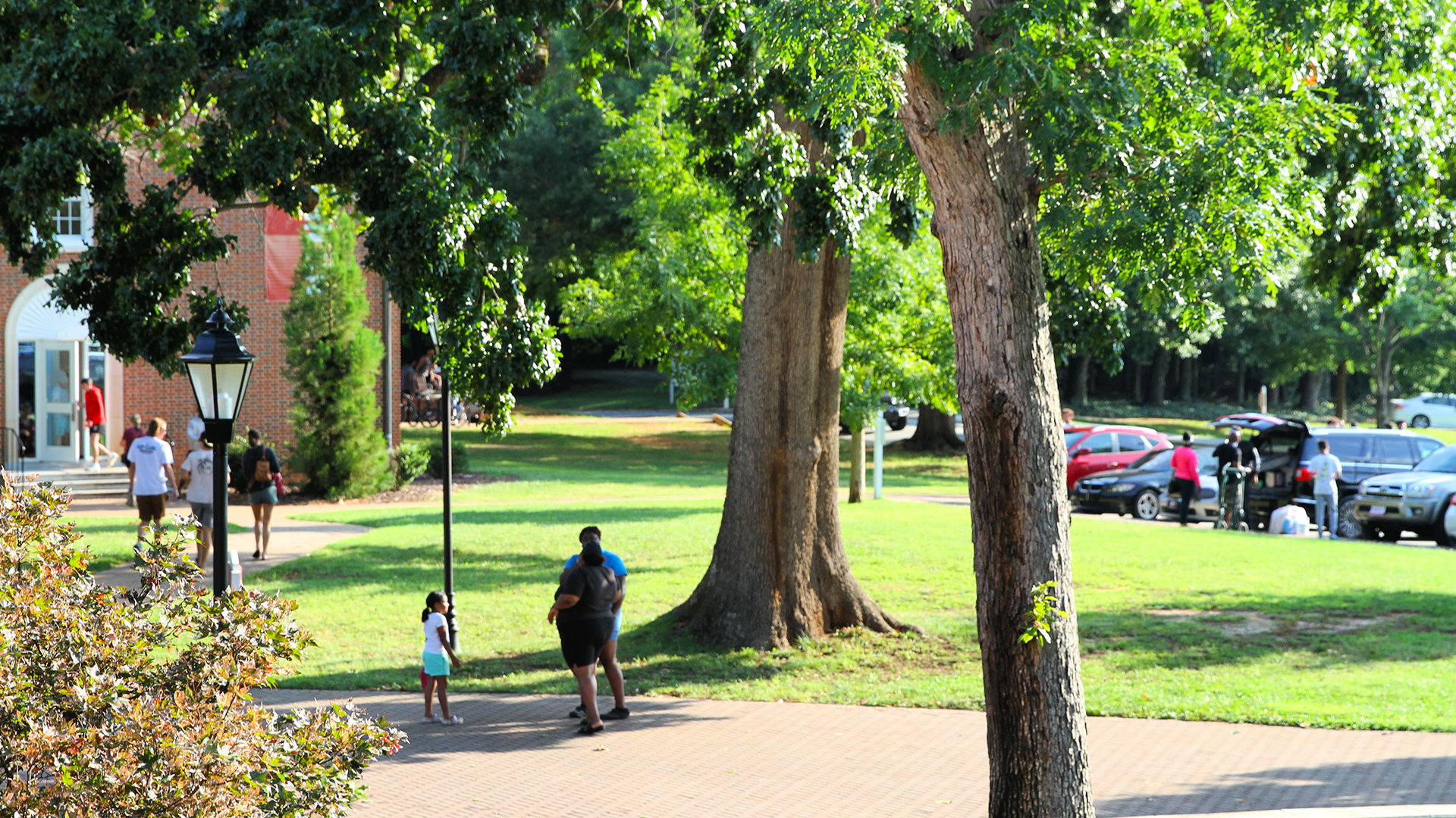 New students and guests walk and chat on campus during move-in.