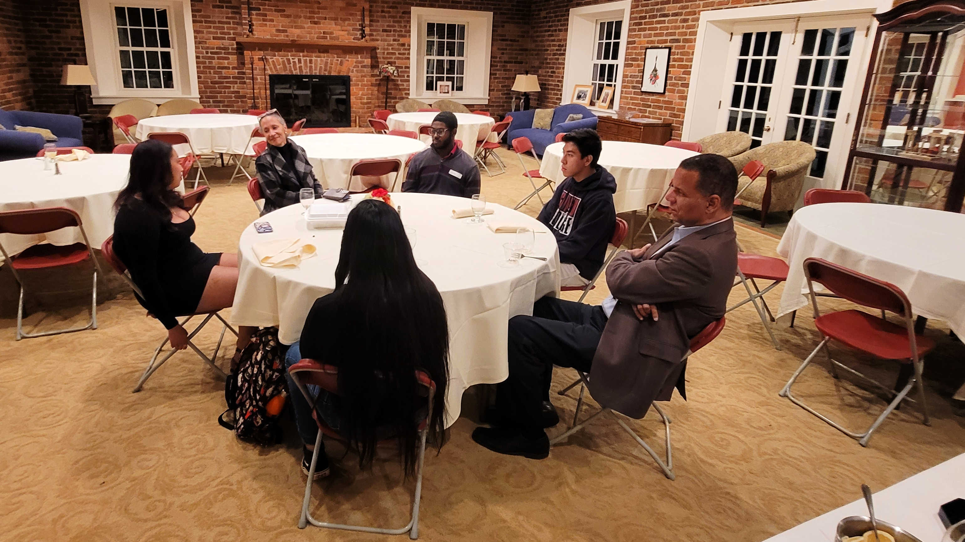 President Kyle Farmbry and his wife, Leilani Martinez, sit around a table and chat with a few of Guilford's first-gen students.