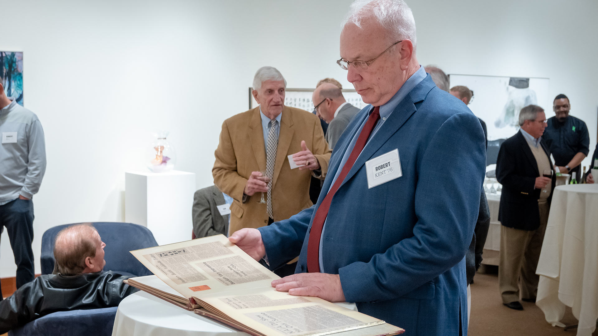 Robert Kent ‘76 looks at a scrapbook of clipping from the men’s basketball team’s championship season.