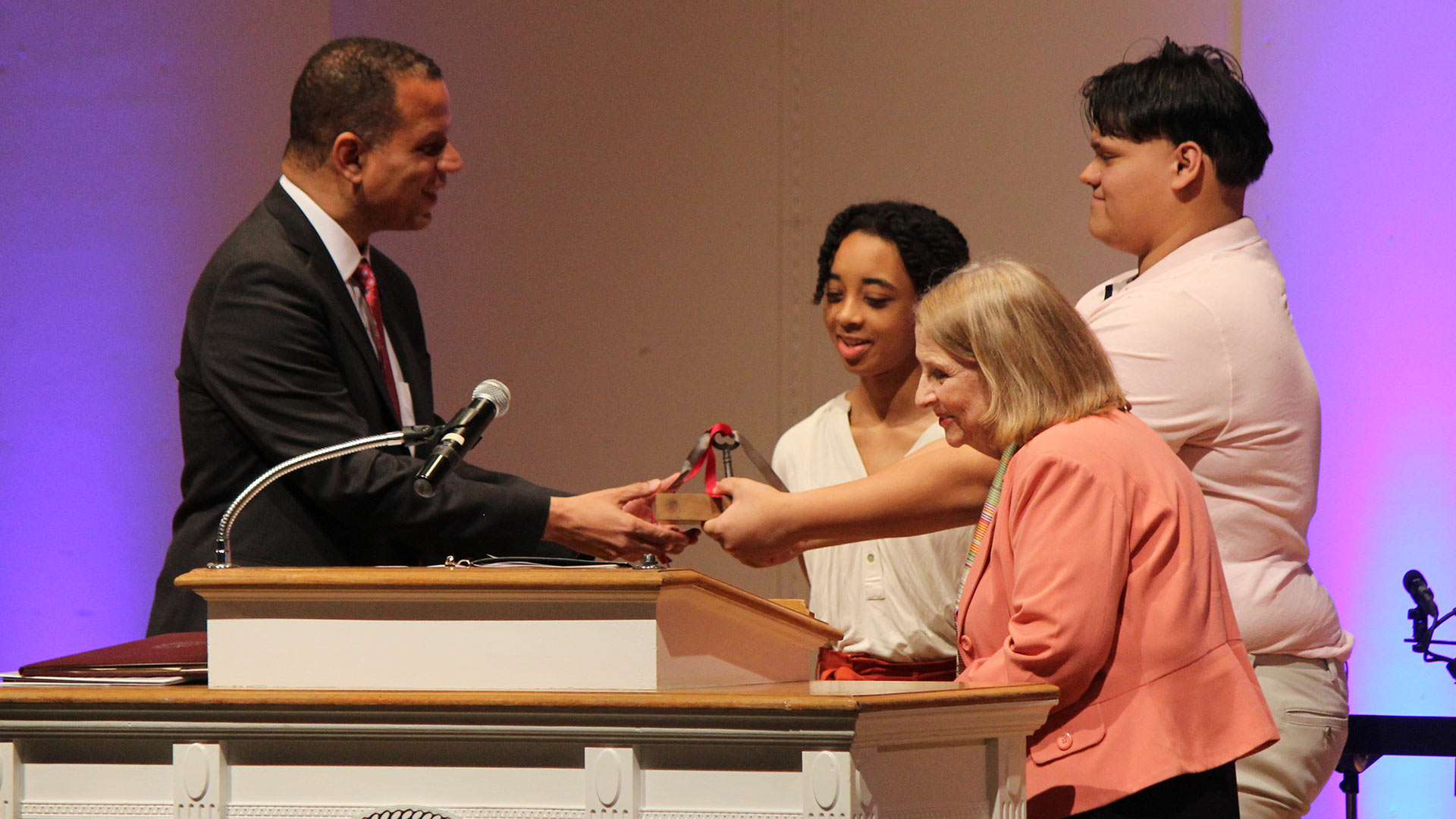 Tinyah Ervin '23 and Michael Mesa '23 join Trustee Chair Ione Taylor '76 to present the keys to the College.
